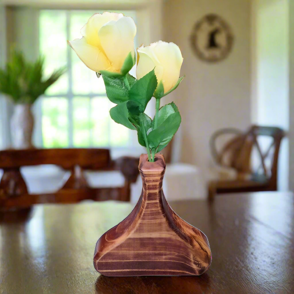 Wooden vase with yellow artificial roses on a white background